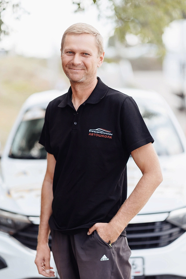 Инструктор с улыбкой у автомобиля