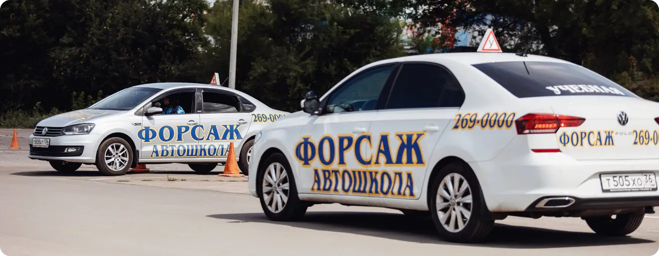 Девушка у двух учебных автомобилей